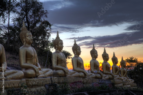 Golden Buddha statues at sunset in Pakse Laos