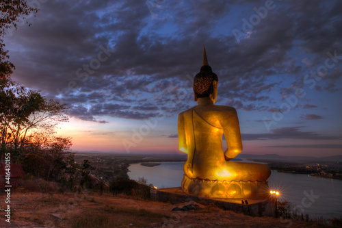 Giant Golden Buddha statue at sunset in Pakse Laos Mekong River