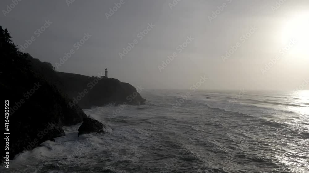 Amazing waves crash on the rocky shoreline beneath North Head Lighthouse, Washington, aerial Amazing waves crash on the rocky shoreline beneath North Head Lighthouse, Washington, aerial