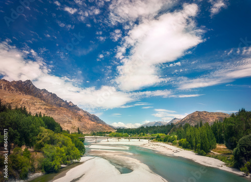 View from the Bridge over Shotover river with the Remarkables mountain in the background, Queenstown, New Zealand. Shotover river was formerly one of the richest gold-bearing rivers in the world. photo