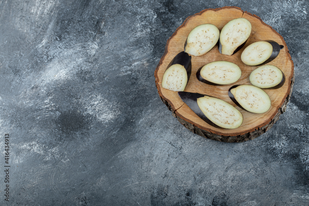 Pile of sliced aubergine on wooden board. Top view Pile of sliced aubergine on wooden board. Top view