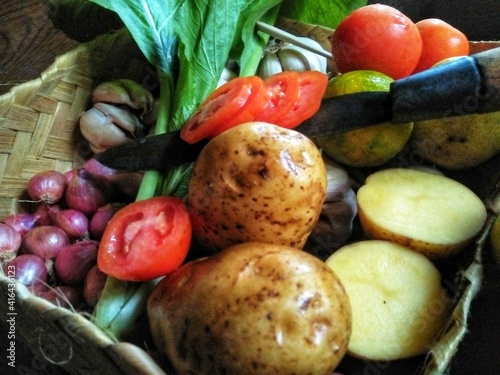 Fototapeta Naklejka Na Ścianę i Meble -  GRESIK CITY, EAST JAVA, INDONESIAN COUNTRY - February 25th, 2020: This photo was taken at noon. This is a photo of some of the vegetables pictured inside a woven bamboo container.