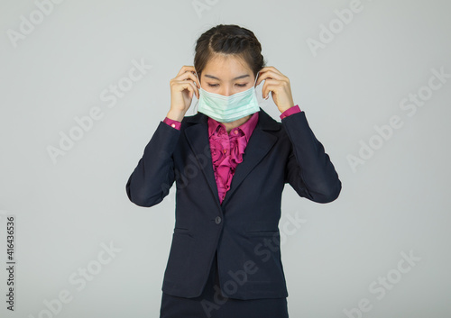 Businesswoman in suit showing how to wear protective medical hygiene mask on face