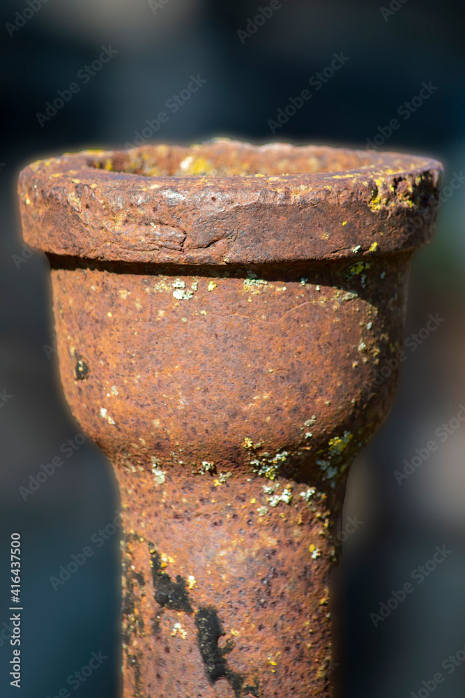 A section of an old sewer pipe. Vertical shot. Blurred dark background. A section of an old sewer pipe. Vertical shot. Blurred dark background.
