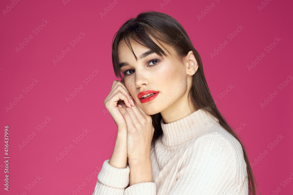Brunette with long hair red lips cosmetics white sweater pink background cropped view Brunette with long hair red lips cosmetics white sweater pink background cropped view