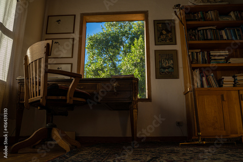 Cozy wooden studio with desk  chair and big sunny green window with a vegetation background Perfect home office