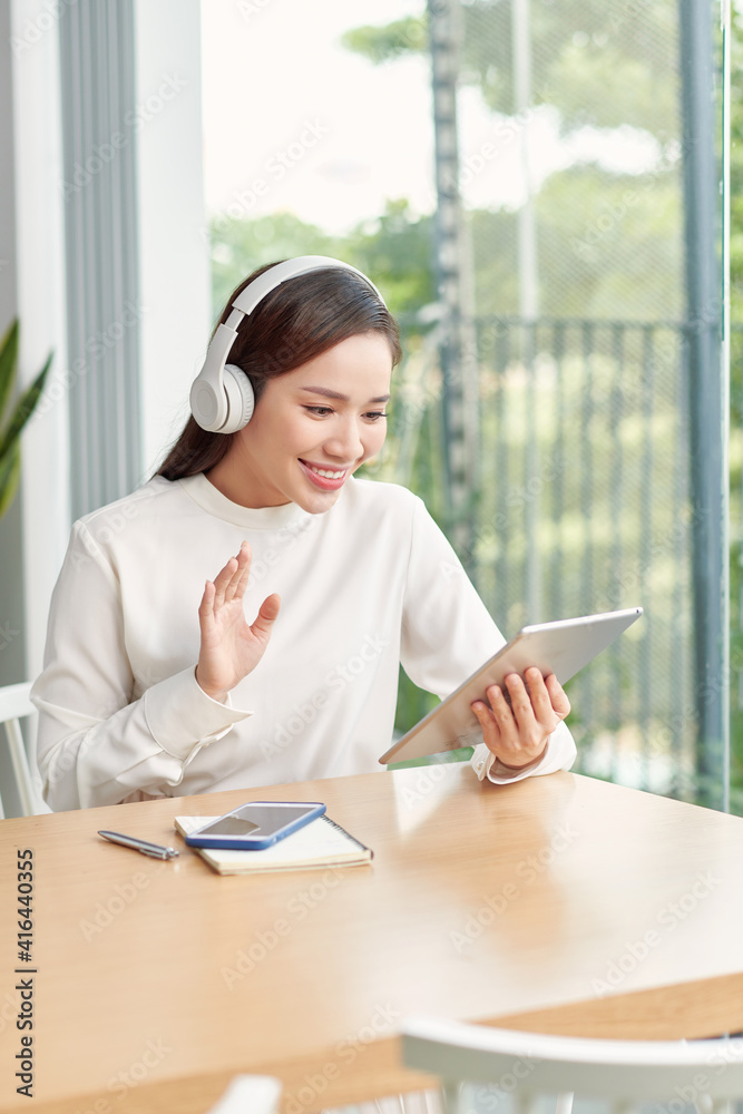 Freelance business woman using tablet working call video conference with customer in workplace in living room at home. Freelance business woman using tablet working call video conference with customer in workplace in living room at home.
