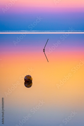 Long exposure abstract landscape with circle and line reflecting in colorful water.