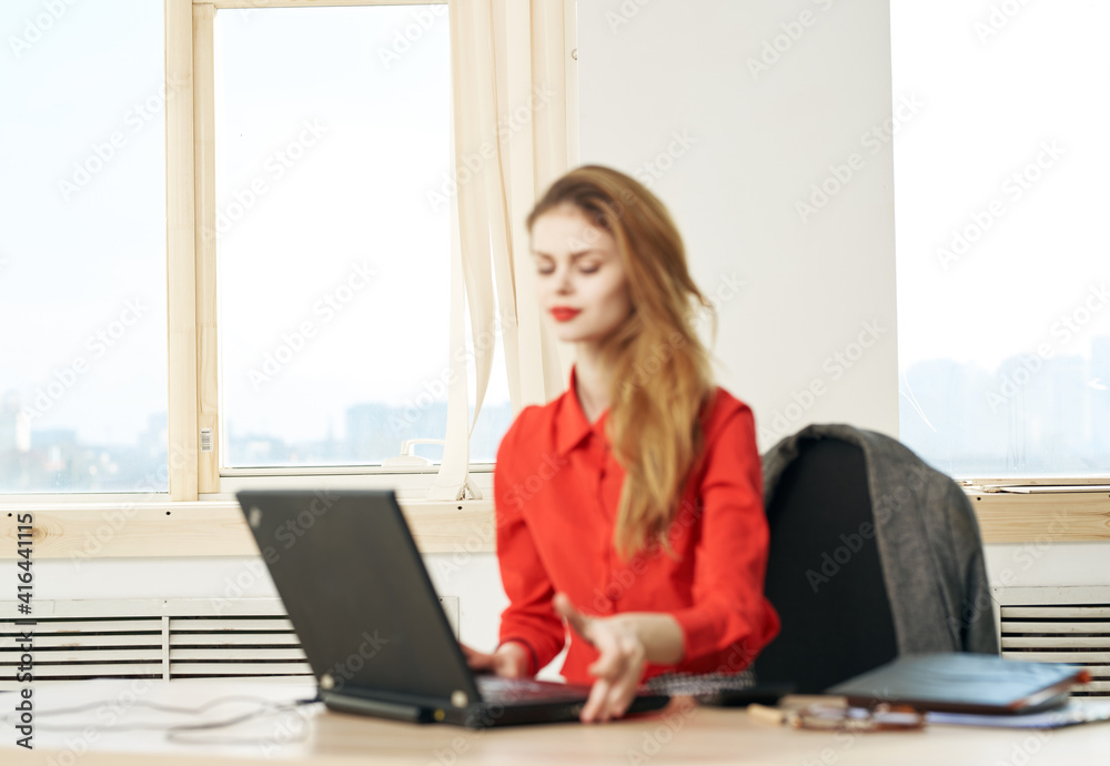 Woman secretary red shirt work desk laptop office manager Woman secretary red shirt work desk laptop office manager