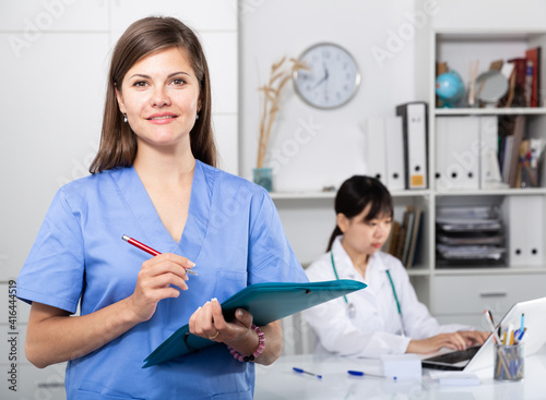 Doctor assistant standing in medical office noting prescriptions. High quality photo