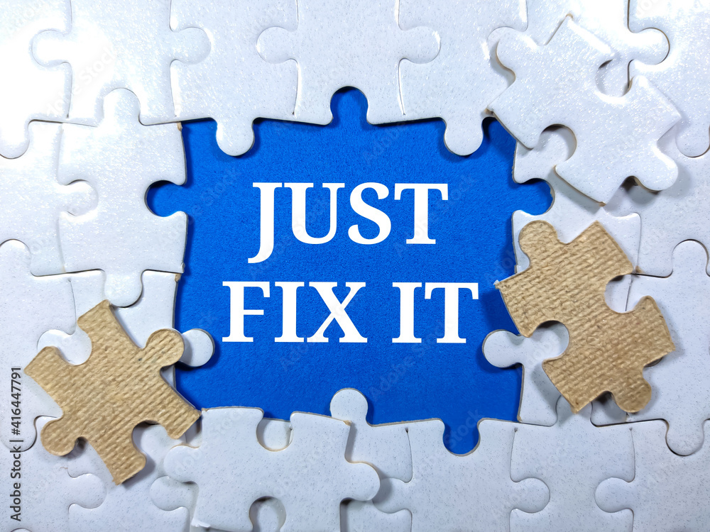 Selective focus.Word JUST FIX IT with jigsaw puzzle on blue background.Business concept. Selective focus.Word JUST FIX IT with jigsaw puzzle on blue background.Business concept.