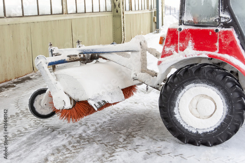 Tractor with rotating cleaning brush for sidewalks and walkways in the city. © aapsky