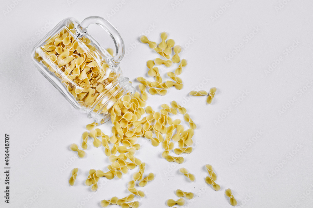 Top view of raw pasta inside the a glass jar on grey background Top view of raw pasta inside the a glass jar on grey background