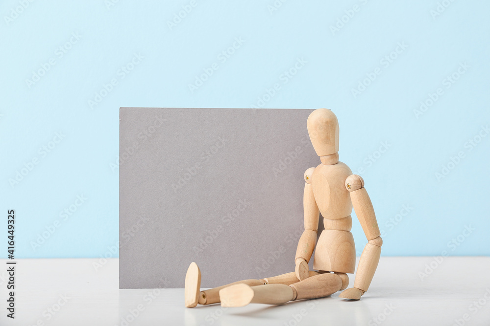 Wooden mannequin with blank poster on color background Wooden mannequin with blank poster on color background