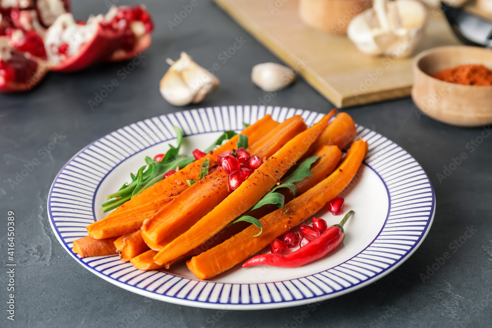 Plate of tasty baked carrot on dark background Plate of tasty baked carrot on dark background