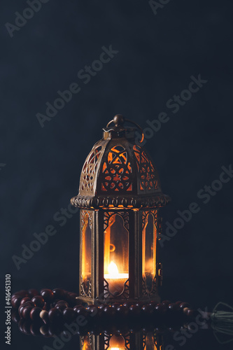 Muslim lamp and tasbih on dark background photo