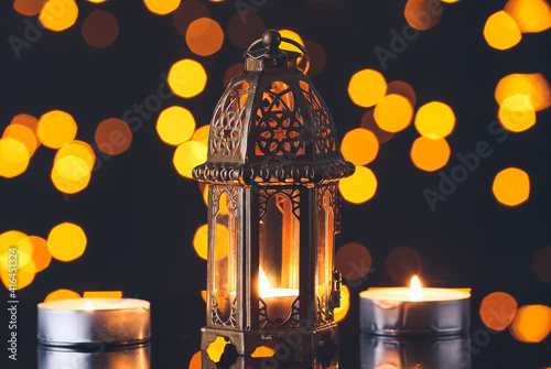 Muslim lamp and candles on dark background with blurred lights