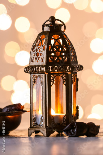 Muslim lamp and dates on light background with blurred lights
