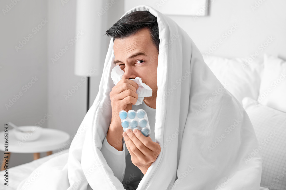 Sick man with pills in bed at home Sick man with pills in bed at home