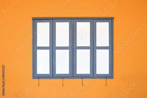 Simple white window on orange concrete wall.