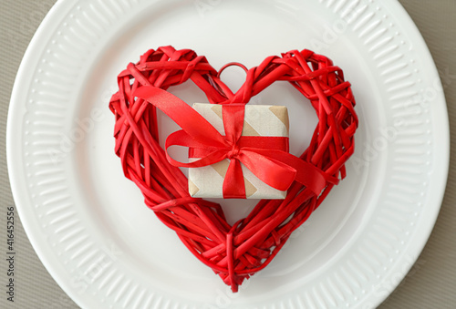 Plate with decorative heart and gift for Valentines Day celebration