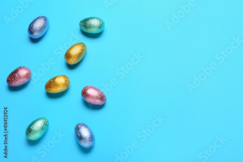 Sweet chocolate eggs on color background
