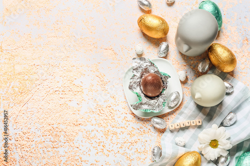 Beautiful composition with chocolate Easter eggs on color background