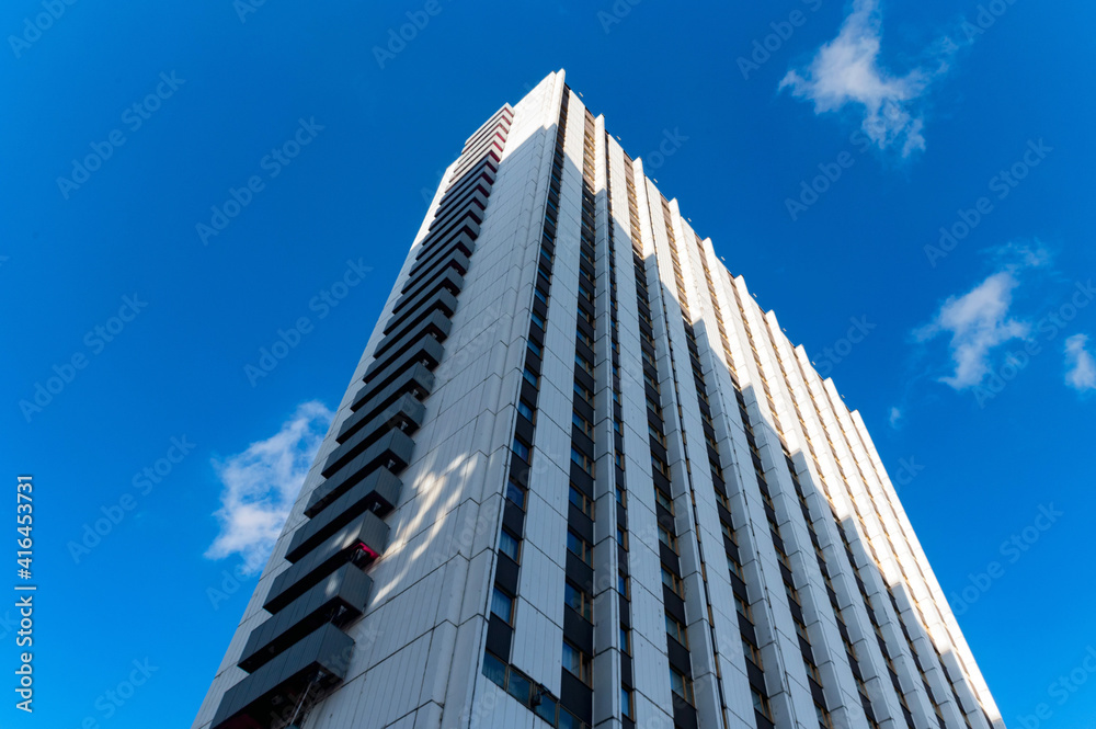 Blue-gray modern multi-storey building against blue sky Blue-gray modern multi-storey building against blue sky