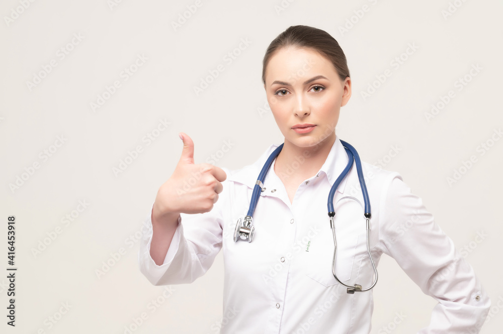 Portrait of an attractive young female doctor showing thumb up gesture