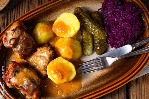 Rustic Snirtjebraten with red cabbage and cucumber photo