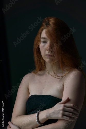 Face Close up of Ginger hair young white woman crossing her arms with black background
