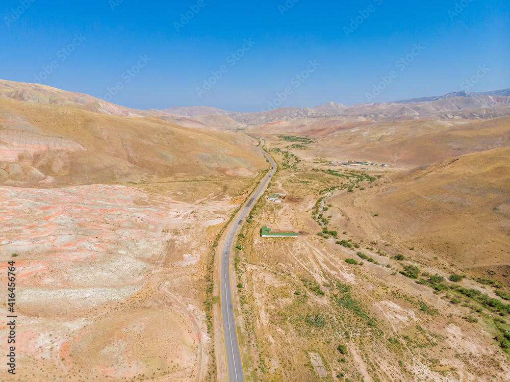 Cross-bedding in Candy Cane Mountains in Azerbaijan and road. Colorful stripes of the hills. Aerial view.