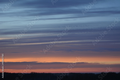 Colorful sunset in winter. Striped clouds in the sky