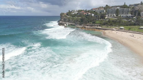 Tourists Walk At Bronte Beach In Summer - Surfers On Surfboard Ride And Enjoying Ocean Waves - NSW, Australia. - aerial photo