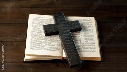 The open book is the holy bible. Scripture. Wooden cross of Jesus.