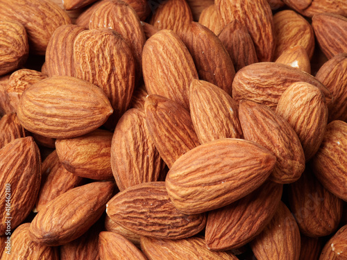 Almond in a bowl on wooden background with copy space