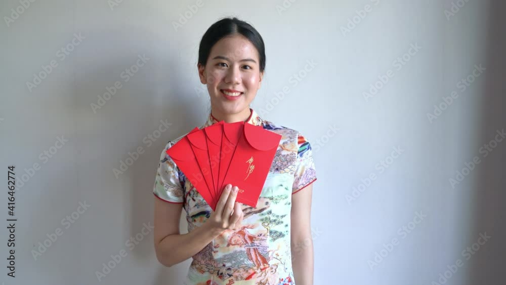 beautiful Asian woman wear Chinese traditional dress with red envelope or red packet beautiful Asian woman wear Chinese traditional dress with red envelope or red packet