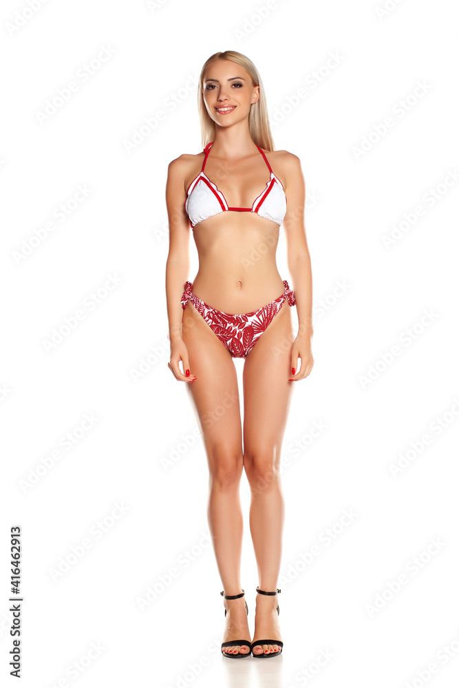 Young woman in bikini, modeling in studio, isolated on white background.