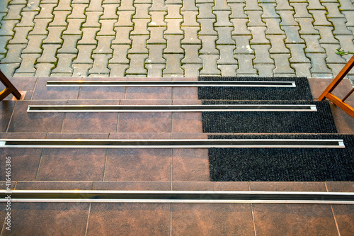 Closeup of ceramic tiles covering porch stairs with rubber anti slippery stripes on it.