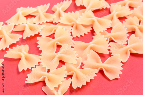 top view of pasta with bows on red background