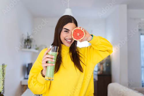Beautiful woman holding glass of smoothie and grapefruit. Healthy lifestyle. Raw food diet, vegetarian nutrition, organic detox meal