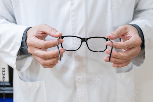 Optician holding glasses in his hands