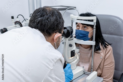 Optician measuring a woman s eyesight