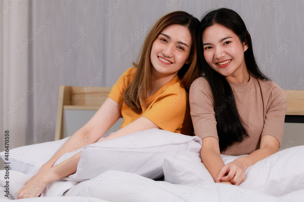 Smiling Two Asian young lovely couple sitting on white bed and happy. Funny women after wake up together on cozy. Concept In love homosexual lesbian lgbt, lgbtq, lgbtq+. Smiling Two Asian young lovely couple sitting on white bed and happy. Funny women after wake up together on cozy. Concept In love homosexual lesbian lgbt, lgbtq, lgbtq+.
