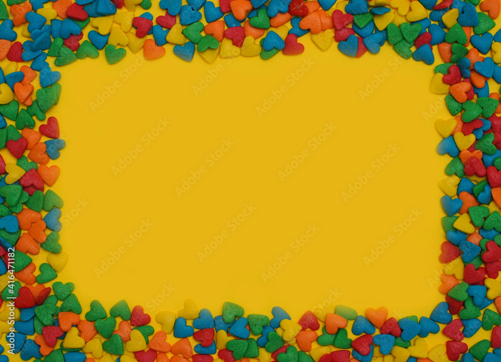  Colorful heart shape sweet candy frame on bright yellow background. Happy birthday greeting card. Holiday background. Sweet candy concept. Flat lay. Holiday Banner. Copy space for text. Love concept.