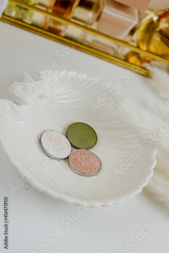 Makeup accessories, round eye shadows on plate and white background