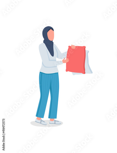 Muslim woman doing laundry flat color vector faceless character. Drying pillows. Housekeeping, home chores. Spring cleaning isolated cartoon illustration for web graphic design and animation