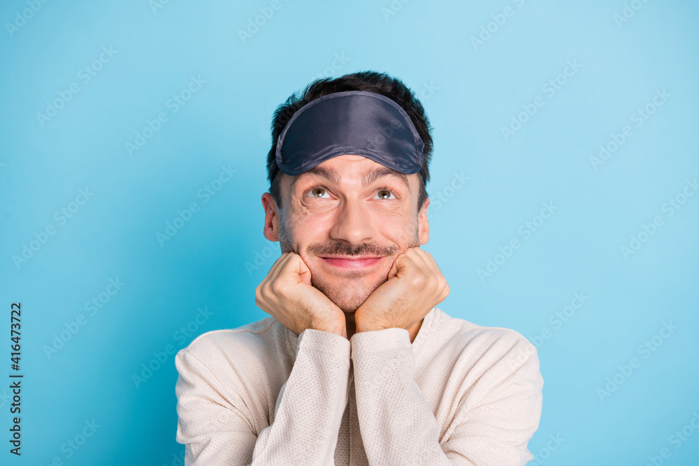 Portrait of nice funny cheery minded brunet guy wearing sleep mask looking up fantasizing isolated over bright blue color background Portrait of nice funny cheery minded brunet guy wearing sleep mask looking up fantasizing isolated over bright blue color background