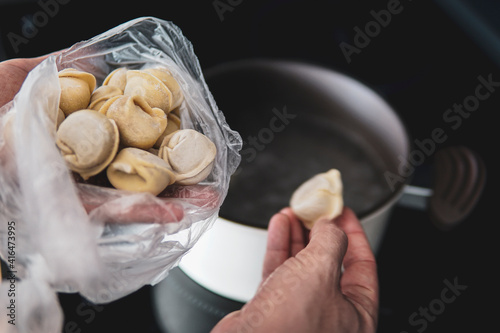 Dumplings from dough with meat are boiled in boiling water. Food photo. The culinary dish Ukrainian dumplings. photo