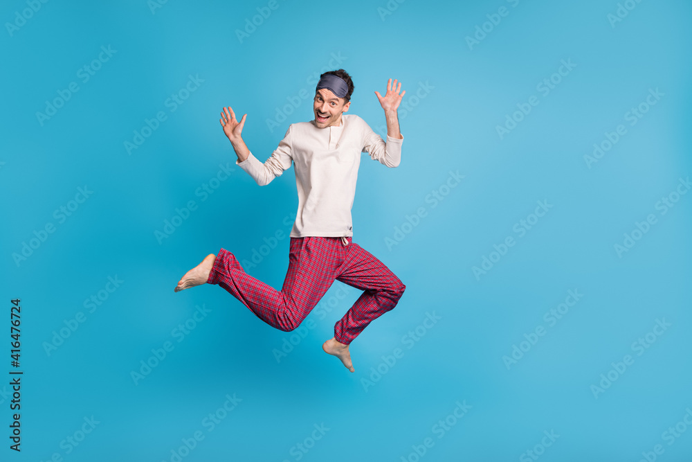 Full length photo portrait of cheerful man showing palms jumping up isolated on vivid blue colored background Full length photo portrait of cheerful man showing palms jumping up isolated on vivid blue colored background